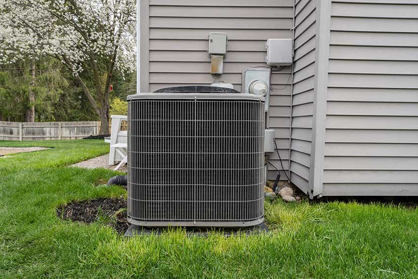 Newly installed residential HVAC condenser on a concrete equipment pad