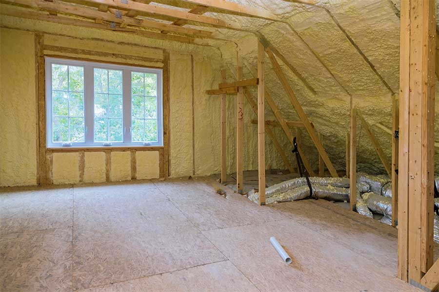 Residential attic insulation installation with wood framing and window in Ceredo WV